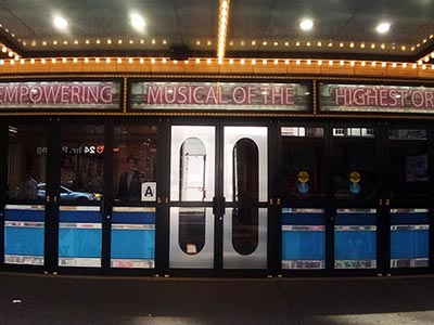 ブルックス・アトキンソン劇場の正面入口の様子。電球で囲われた照明、看板の文字がネオン管だったりと、1950～60年代の雰囲気が特徴